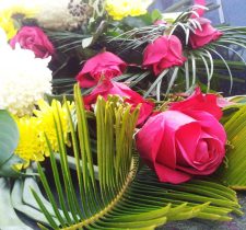 Mourning flower arrangement with red roses and white and yellow chrysanthemums