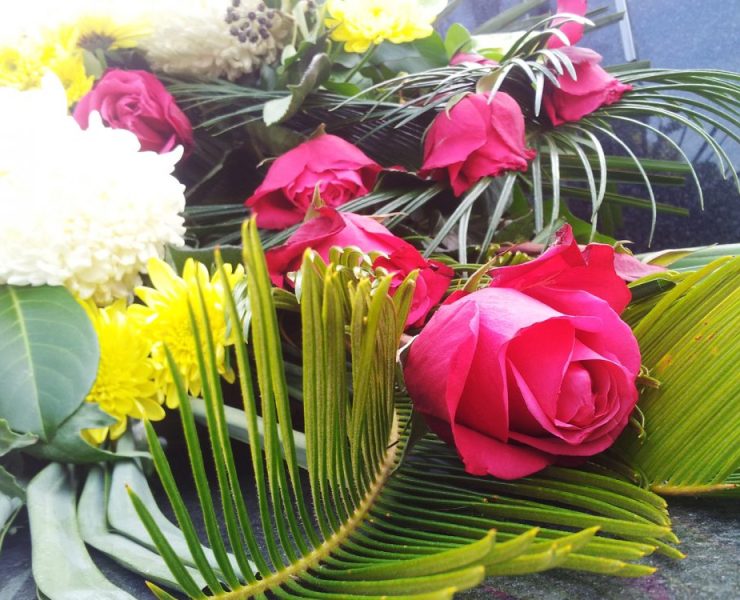 Composizione floreale funebre con rose rosse e crisantemi bianchi e gialli