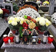 Grave decorated with flowers, funeral wreaths and memorial candles
